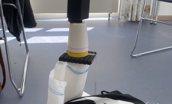 Zu sehen ist ein Turm, der aus verschiedenen Materialien zusammengebaut wurde. Hier hauptsächlich aus Plastikbechern, Küchenpapier und diveresm Material aus dem moderationskoffer. 