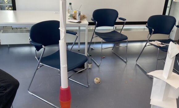 Zu sehen ist ein Turm, der aus verschiedenen Materialien zusammengebaut wurde. Hier hauptsächlich aus Plastikbechern und Papier.