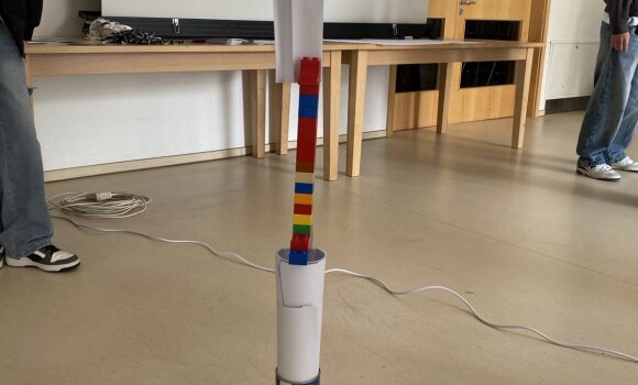 Zu sehen ist ein Turm, der aus verschiedenen Materialien zusammengebaut wurde. In diesem Fall hauptsächlich Bauklötze und Papier.