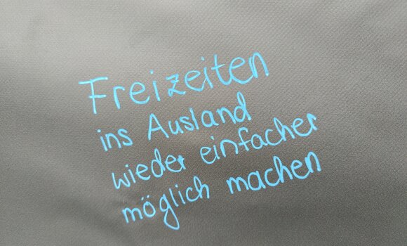 Auf schwarzem Hintergrund steht "Freizeiten im Ausland wieder einfacher möglich machen."