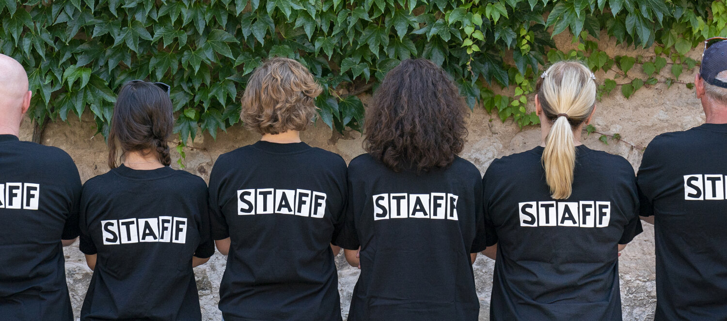 Projektteamfoto von hinten. Der Schriftzug "Staff" ist auf den T-Shirts zu lesen. 