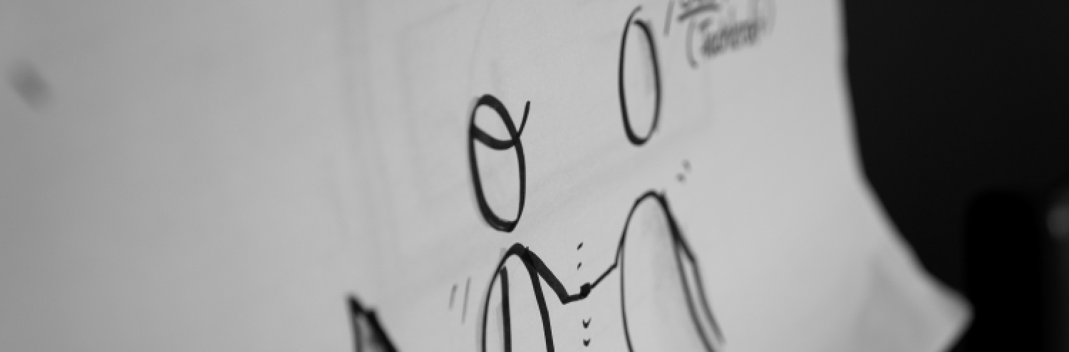 Zu sehen sind zwei Strichfiguren auf einem Flipchart, die einander zugewandt sind.